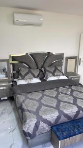 a bedroom with a bed with a black and white comforter at Airport sky in Amman