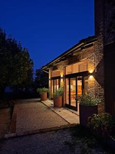 a brick building with doors and windows at night at Lungamerenda in Costigliole dʼAsti