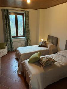 a bedroom with two beds and a window at Lungamerenda in Costigliole dʼAsti
