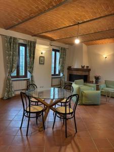 a dining room with a glass table and chairs at Lungamerenda in Costigliole dʼAsti