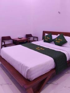 a bedroom with a large bed with two chairs at MR SIETS hotel in Châu Xá