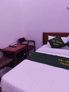 a bedroom with a bed and a table and a chair at MR SIETS hotel in Châu Xá