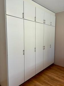 a row of white cabinets in a room at Huoneisto Vipunen in Savonlinna