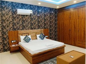a bedroom with a bed and a wall at Hotel Grand Radhe Krishna inn in Vrindāvan
