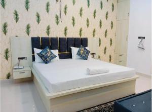 a bedroom with a large white bed with blue pillows at Hotel Grand Radhe Krishna inn in Vrindāvan +14 photos