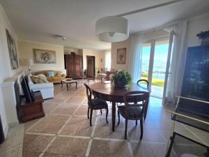 a living room with a table and chairs at Queen Apartment - Stunning Panoramic Island View in Baveno +23 photos