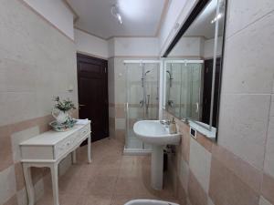 a white bathroom with a sink and a mirror at Queen Apartment - Stunning Panoramic Island View in Baveno