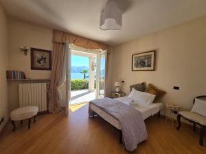 a bedroom with a bed and a sliding glass door at Queen Apartment - Stunning Panoramic Island View in Baveno