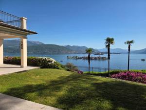 a house with a view of the water and palm trees at Queen Apartment - Stunning Panoramic Island View in Baveno