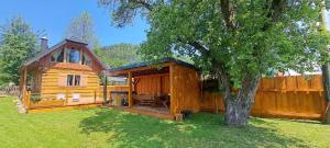 a large wooden cabin with a tree in the yard at Drevenička Zázrivá Terchová in Zázrivá
