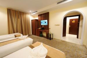a hotel room with a bed and a desk at فندق اللؤلؤة البلاتيني - Platinum Pearl Hotel in Medina