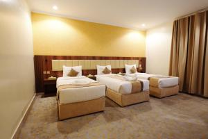a hotel room with two beds and two chairs at فندق اللؤلؤة البلاتيني - Platinum Pearl Hotel in Medina +45 photos