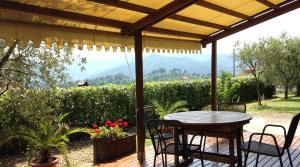 a table and chairs on a patio with a view at Appartamenti Residence Montebello, relax con giardino e piscina in Bolano