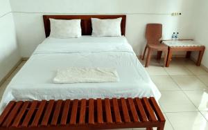 a bed with a wooden bench in a room at Filomena Lodge in Ende