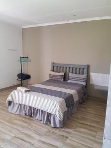 a bedroom with a large bed with striped sheets at Bredell Motel in Bredell