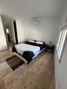 a bedroom with a bed and a tile floor at Les remparts de Sasha in Lapalme