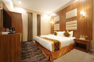 a hotel room with a bed and a television at شقق اللؤلؤة الذهبي - Golden Pearl Apartments in Sīdī Ḩamzah