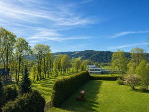 a garden with a bench and trees and a building at Willa Park in Zakopane