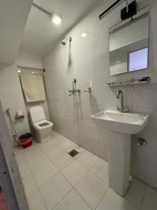 a white bathroom with a sink and a toilet at Sunny Guest House and Cafe in Bhaktapur +47 photos