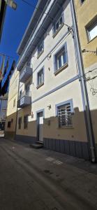 a white building with windows on a street at Althea B&B in Schiavonea