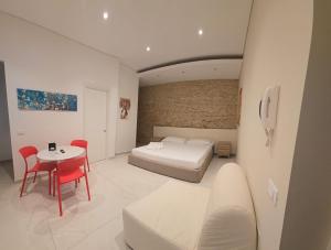 a bedroom with a bed and a table and chairs at Althea B&B in Schiavonea