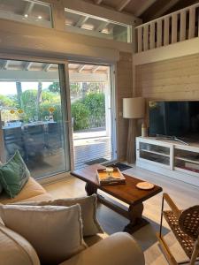a living room with a couch and a table at Californian style chalet in Gassin