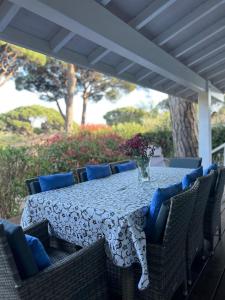 a table with blue chairs and a vase of flowers at Californian style chalet in Gassin