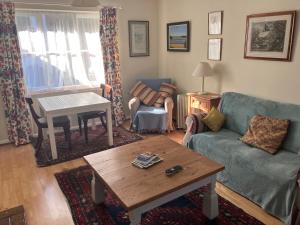 ein Wohnzimmer mit Sofa und Tisch in der Unterkunft Snipe Vineyard Cottage in Woodbridge