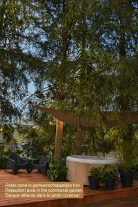 a table and chairs under a tree in a garden at Cacele - La croisette 5 appartementen en 6 tweepersoonskamers met jacuzzi in Vresse-sur-Semois +67 photos