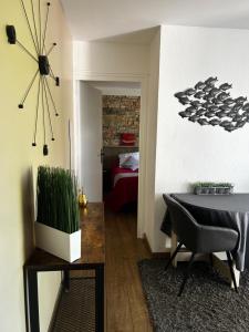 a dining room with a table and a clock on the wall at Chambre d'hôtes de la Riaille 400 m de la dolce via in Le Cheylard