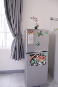 a refrigerator in a kitchen next to a window at Xuan Luom Guesthouse in Phan Thiet