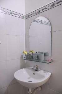 a white bathroom with a sink and a mirror at Xuan Luom Guesthouse in Phan Thiet +49 photos