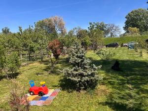 a toy train sitting on a blanket next to a christmas tree at Vikendica Aurora in Šabac