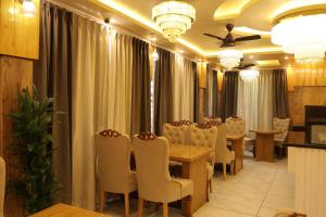 a dining room with a table and chairs at Hotel M Sarthak Dehradun in Dehradun