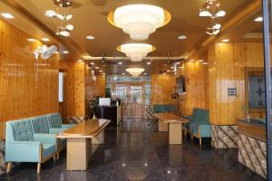 a restaurant with wooden walls and blue chairs and tables at Hotel M Sarthak Dehradun in Dehradun