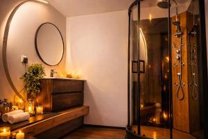 a bathroom with a shower and a sink and a mirror at Le Bain des VioIettes - Grand jacuzzi privatif in Dole