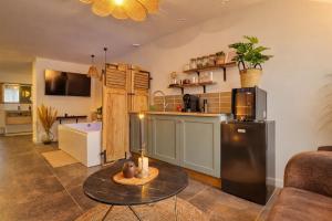 a kitchen and living room with a table and a refrigerator at L'Ecrin des Monts in Bailleul