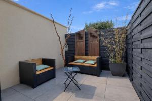 two chairs and a table on a patio at L'Ecrin des Monts in Bailleul