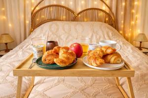 a tray of croissants and apples on a bed at L'Ecrin des Monts in Bailleul