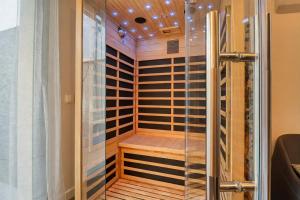a sauna with a glass shower in a room at L'Ecrin des Monts in Bailleul