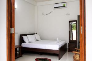 a bedroom with a bed and a mirror at Butterfly Homestead Hotel in Udawalawe