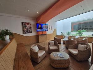 a lobby with chairs and a flat screen tv at La Casita di Fuerte in Caleta De Fuste