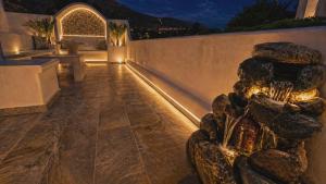 a fountain in the middle of a patio at night at Papafotis Apartments & Suites in Alinda +93 photos