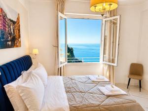 a bedroom with a bed and a large window at Vertigini Suites, Il Rifugio dell Amore per SOLE COPPIE , A 50m dalla Stazione e dalla Via dell Amore con Vista Mare e Intimità Appagante in Riomaggiore