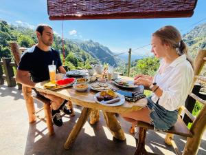 a man and woman sitting at a table eating food at Velora Inn in Ella