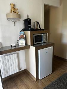 a small kitchen with a microwave on a counter at Chambre d'hôtes de la Riaille 400 m de la dolce via in Le Cheylard