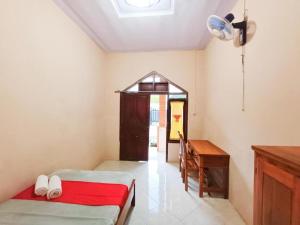 a room with two beds and a desk and a window at TepiKota Inn in Banyuwangi