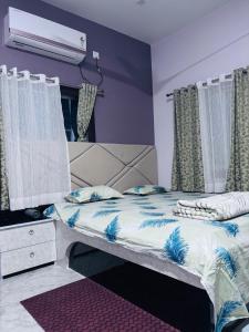a bedroom with a bed with blue and white sheets at Ashirwad Niwas in Bokāro