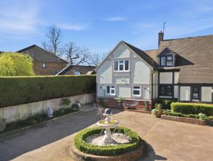 a house with a fountain in front of it at The Luxe Pool House, Westoning in Westoning