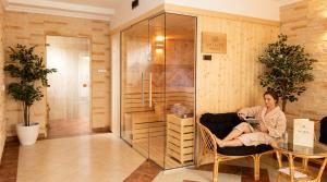 a woman sitting in a chair in a room at Antalya Pokoje i Apartamenty in Władysławowo